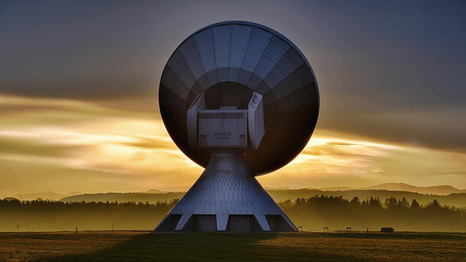A white satellite dish antenna pointed toward the sky.